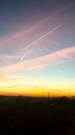 Scenic view of vapor trails in sky during sunset