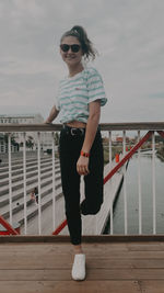 Full length of man standing by railing against sky