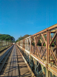 Footbridge against clear blue sky