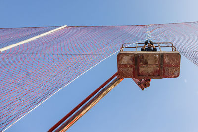 Low angle view of crane against clear sky