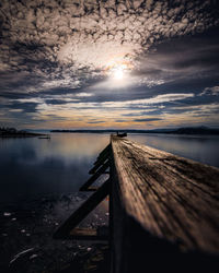 Pier over lake against sky during sunset