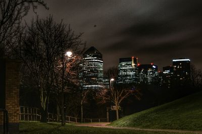 Illuminated buildings in city against sky at night