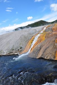 Scenic view of rocky shore against sky