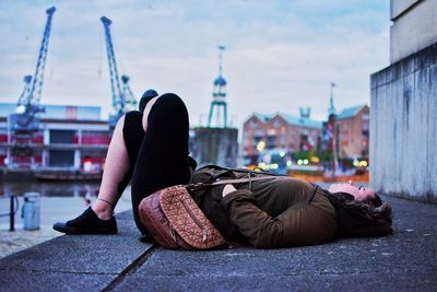 Young woman lying on footpath by river