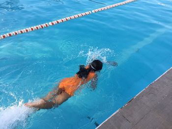 Rear view full length of girl swimming in pool