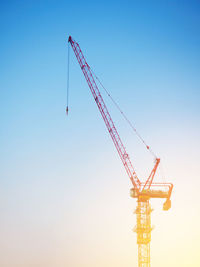 Low angle view of crane against clear sky