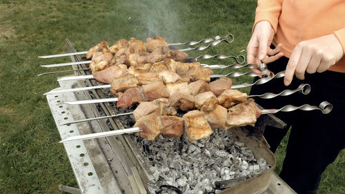 Woman turning skewers on a grill