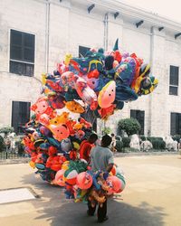 Multi colored balloons on tree in city