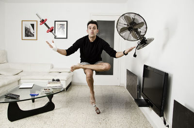 Full length of man balancing on bottle while standing