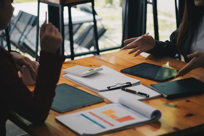 Midsection of business people having discussion at office