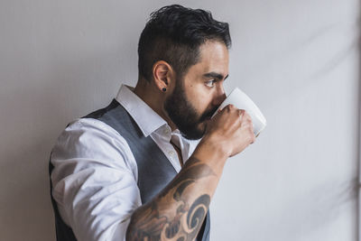 Handsome man dressed as executive drinking coffee