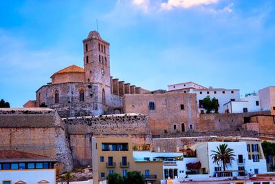 Low angle view of castle and buildings against sky