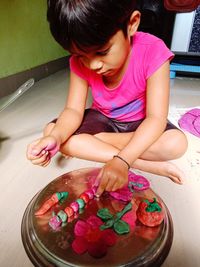 High angle view of girl playing with pink balloons