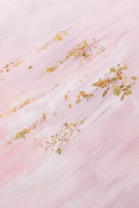 Delicate pink marble background with gold brushstrokes. place for your design.