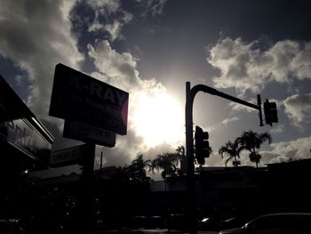Low angle view of road sign against cloudy sky