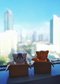 Close-up of toys on table against buildings in city