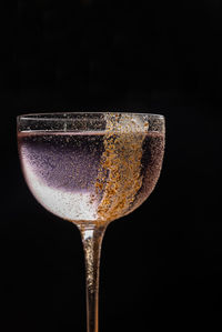 Close-up of wineglass against black background