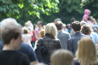 Rear view of people against trees