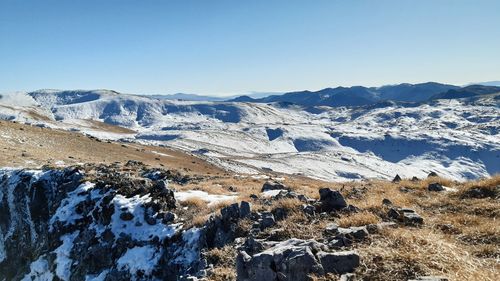 Scenic view of snowcapped mountains against clear blue sky