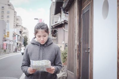 Woman reading map in city