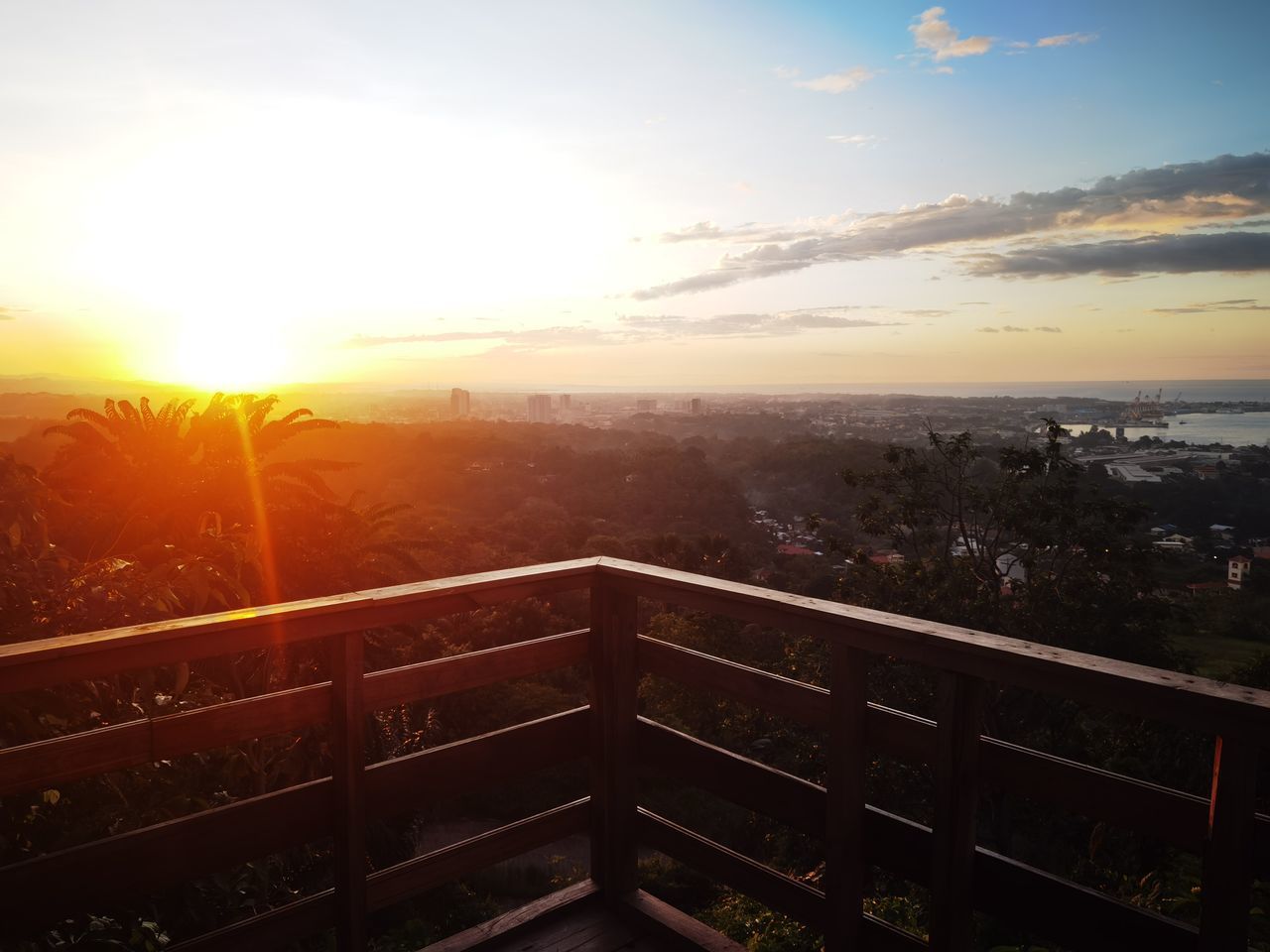 sky, sunset, sun, nature, architecture, sunlight, cloud, city, horizon, lens flare, built structure, evening, landscape, dawn, scenics - nature, building exterior, no people, beauty in nature, sunbeam, environment, outdoors, cityscape, building, tranquility, railing, tranquil scene, orange color, high angle view, travel destinations, residential district, urban skyline, dramatic sky, idyllic, aerial view