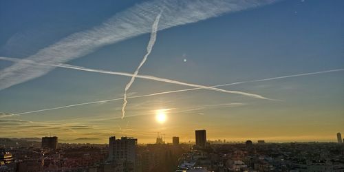 Buildings in city against sky during sunset