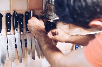 Close-up of man picking knife at home