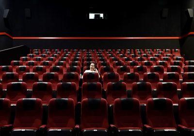 Rear view of people sitting in empty chairs