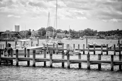 View of marina in river against cloudy sky