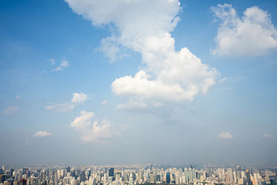 Panoramic view of buildings against cloudy sky