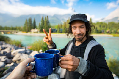 Portrait of man holding ice cream in lake