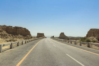 Road against clear blue sky