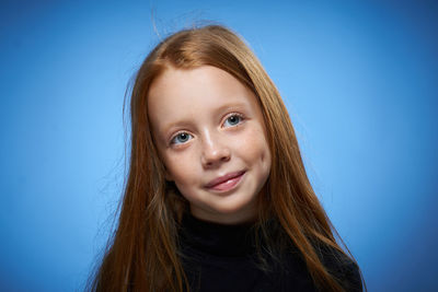 Close-up of young woman against blue background