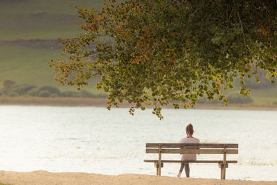 Young girl by the lake of remoray sitting alone on a bench