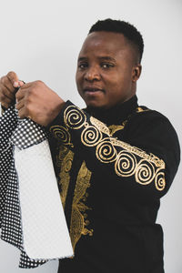 Portrait of man standing against white background