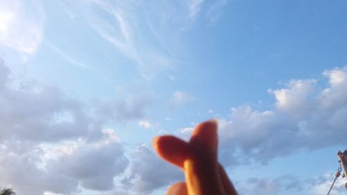 Low angle view of hand against sky