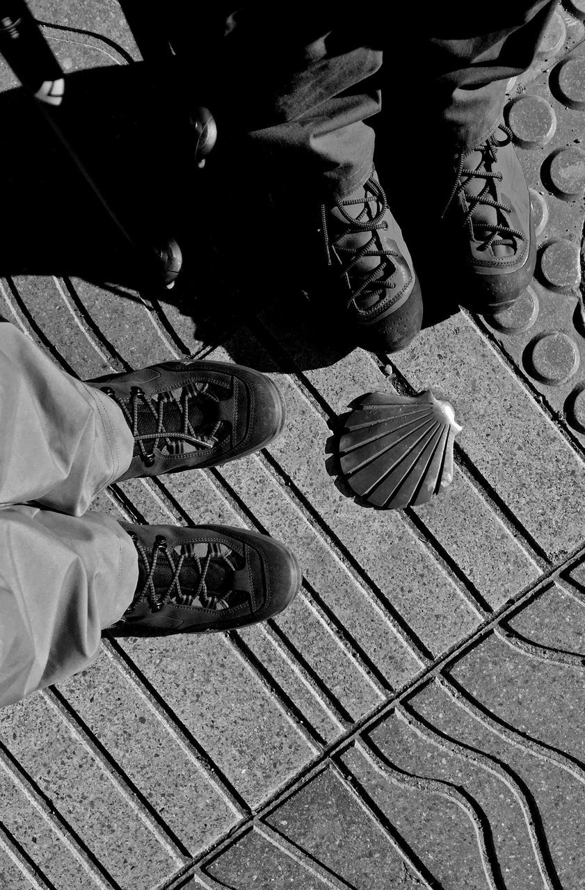 LOW SECTION OF MAN SITTING ON FLOOR AGAINST WALL