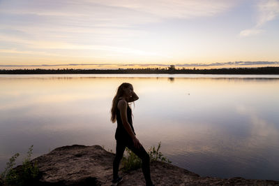 Traveler woman walking by the lake during sunset.