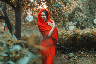 Portrait of young woman standing on mobile phone