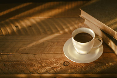 Coffee cup with light and shadow on old wood, morning with coffee