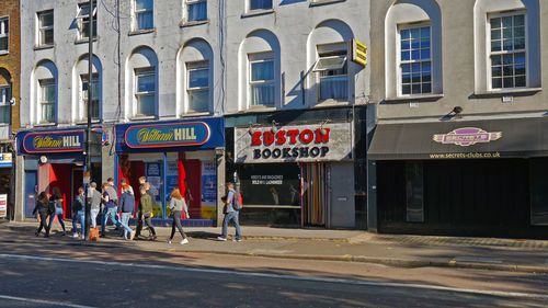 People walking on road by building in city