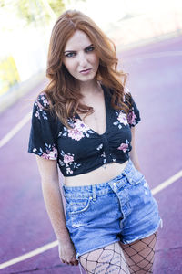 Portrait of beautiful woman standing on road