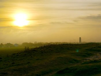 Scenic view of field against sky during sunset