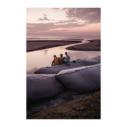 People on beach against sky during sunset