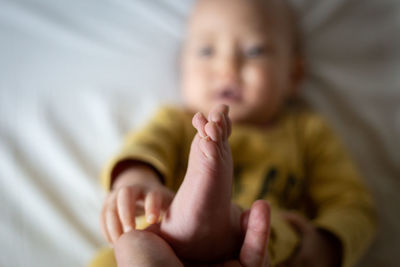 Close-up of baby boy lying on bed at home