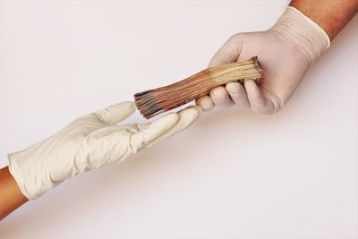 Midsection of man holding cake against white background