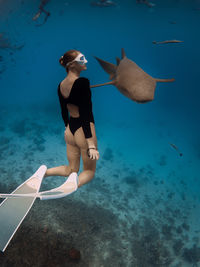 Rear view of woman swimming in sea