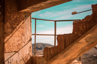 Close-up of old wall by sea against sky