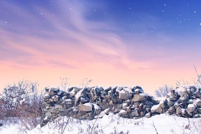 Scenic view of snow covered landscape against sky during sunset