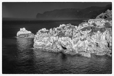 Rocks by sea against sky